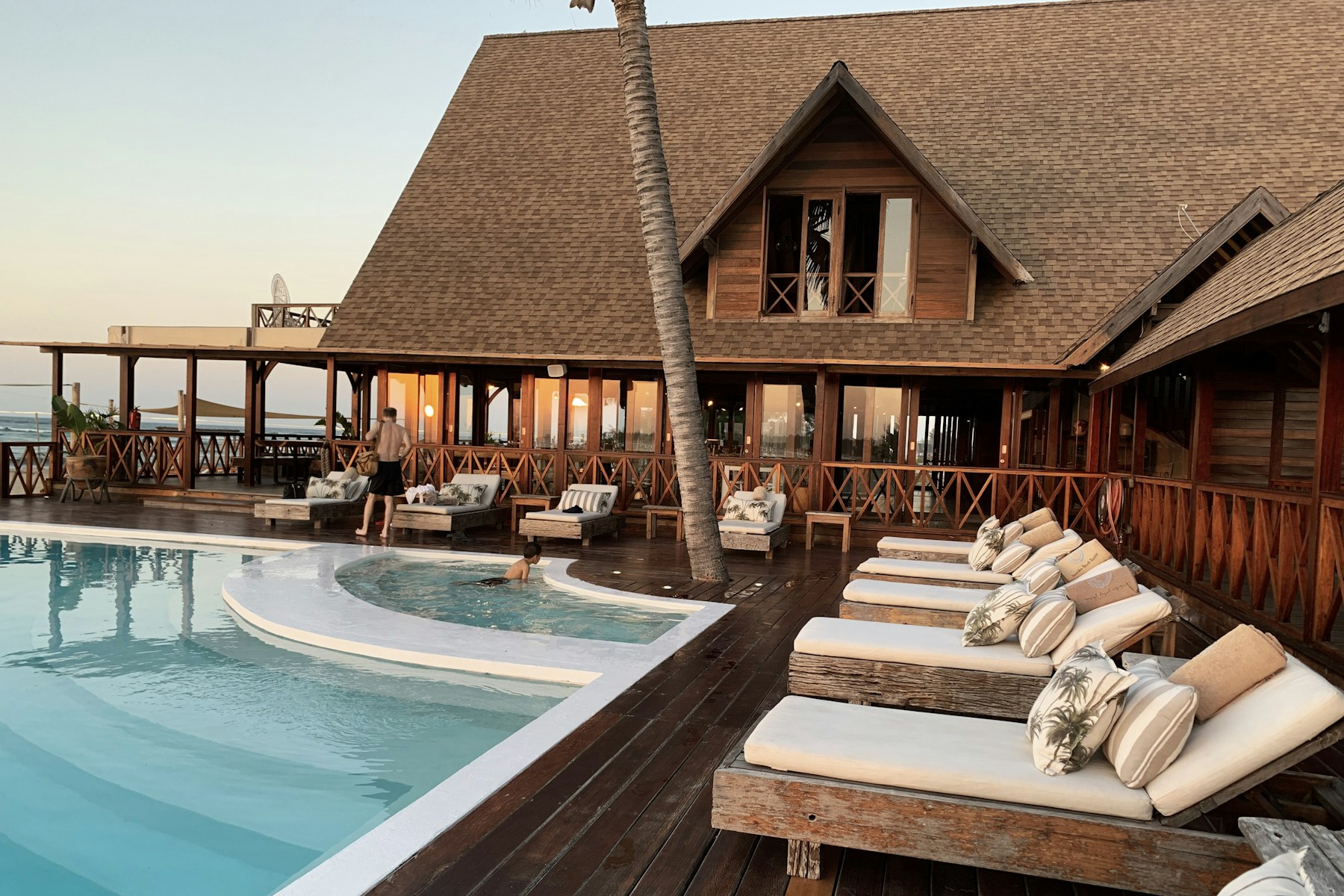Luxury beach resort with palms, pool, and modern hotel rooms